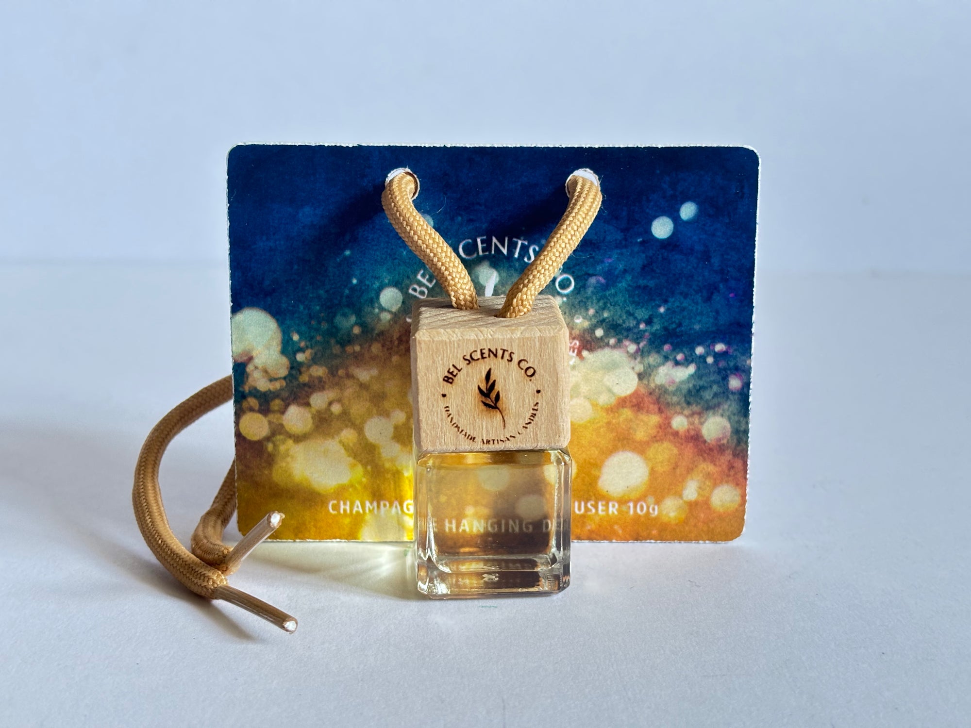 Scented hanging car diffuser bottle with wooden cap, suspended by string. Fruity Fragrance Minimalist hanging diffuser for car interior. Hanging fragrance diffuser with Wood-topped diffuser adding a refreshing scent to a car interior. filled with essential oils for natural fragrance