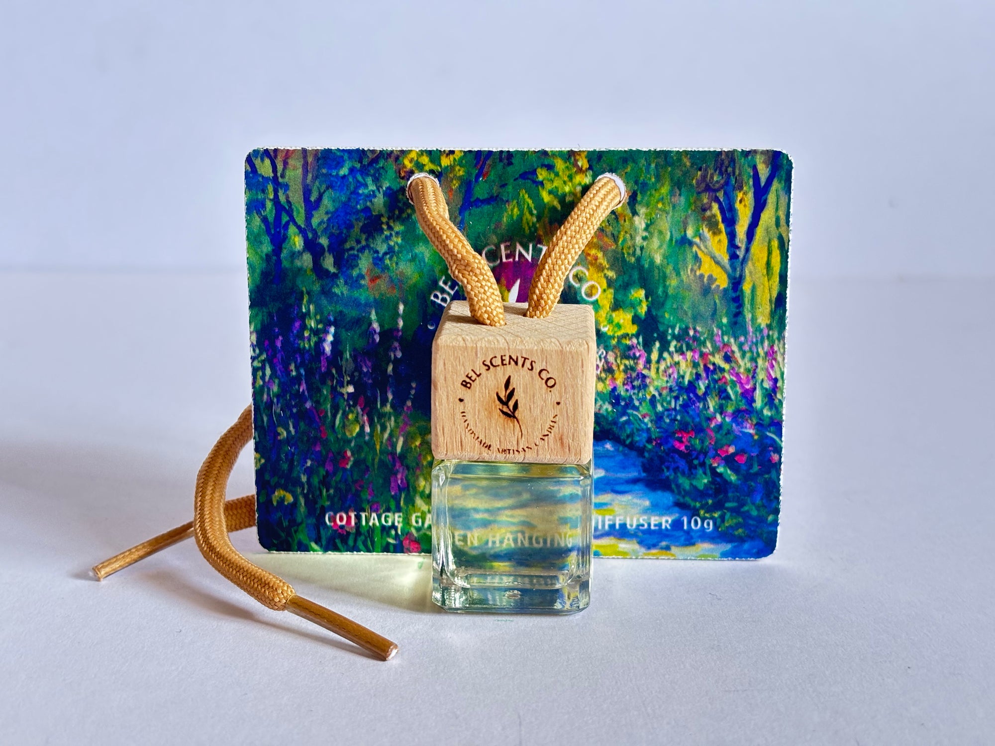 Cottage Garden floral Scented hanging car diffuser bottle with wooden cap, suspended by string. Minimalist hanging diffuser for car interior. Hanging fragrance diffuser with Wood-topped diffuser adding a refreshing scent to a car interior. filled with essential oils for natural fragrance