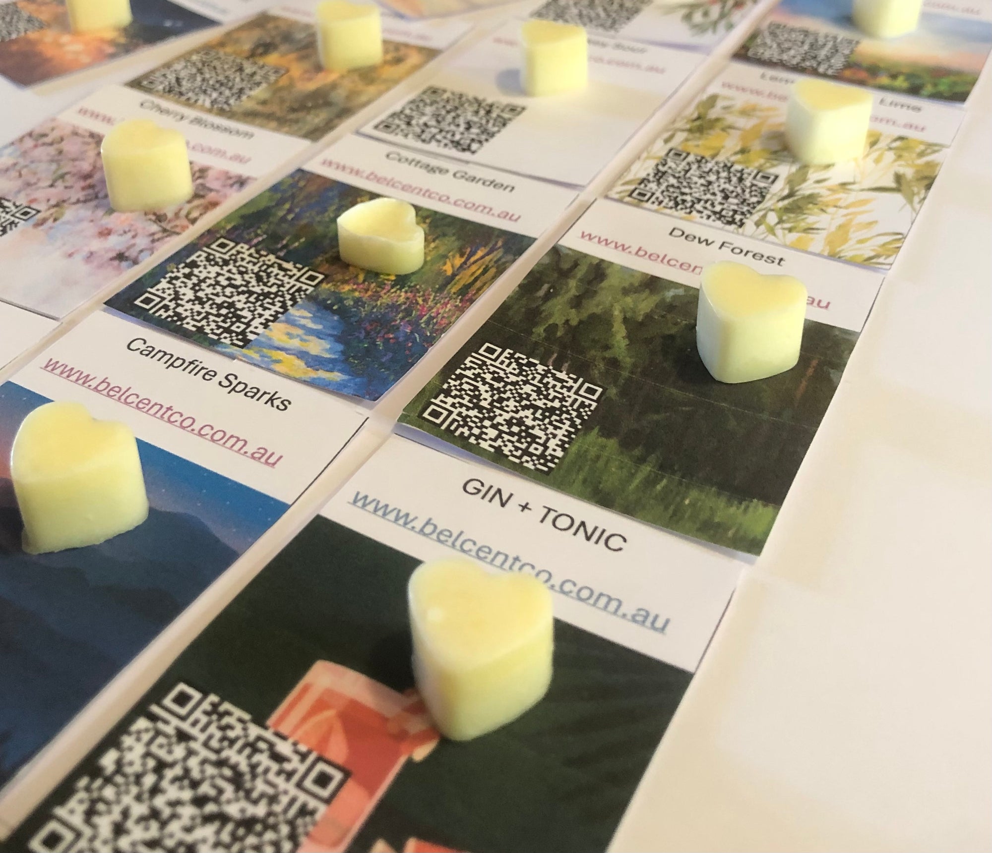 Candle melts on top of Bel Scents Co.product packaging with QR codes.