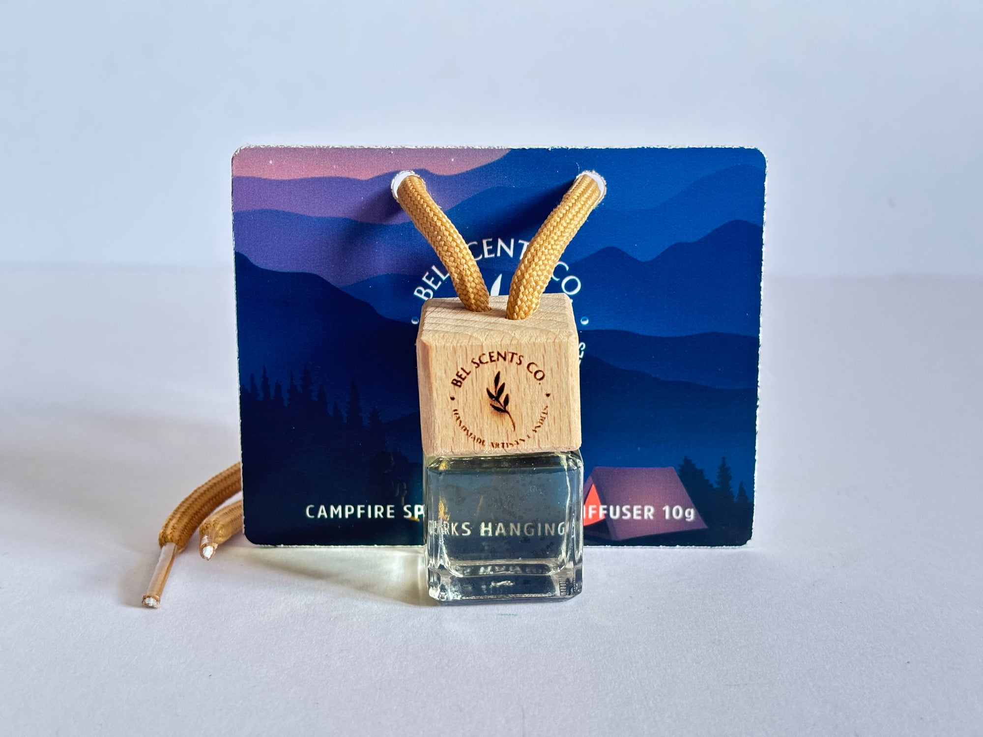 Vanilla Car Fragrance. Scented hanging car diffuser bottle with wooden cap, suspended by string. Minimalist hanging diffuser for car interior. Hanging fragrance diffuser with Wood-topped diffuser adding a refreshing scent to a car interior. filled with essential oils for natural fragrance