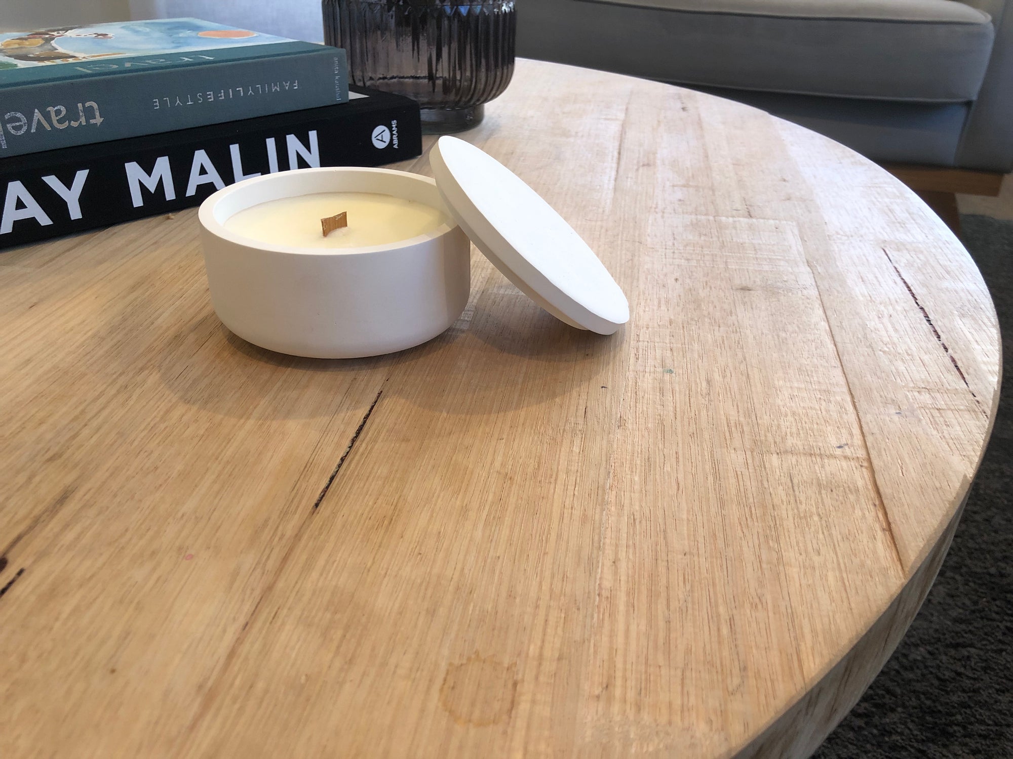 White Concrete Candle on Coffee Table setting with books and relaxed look in background