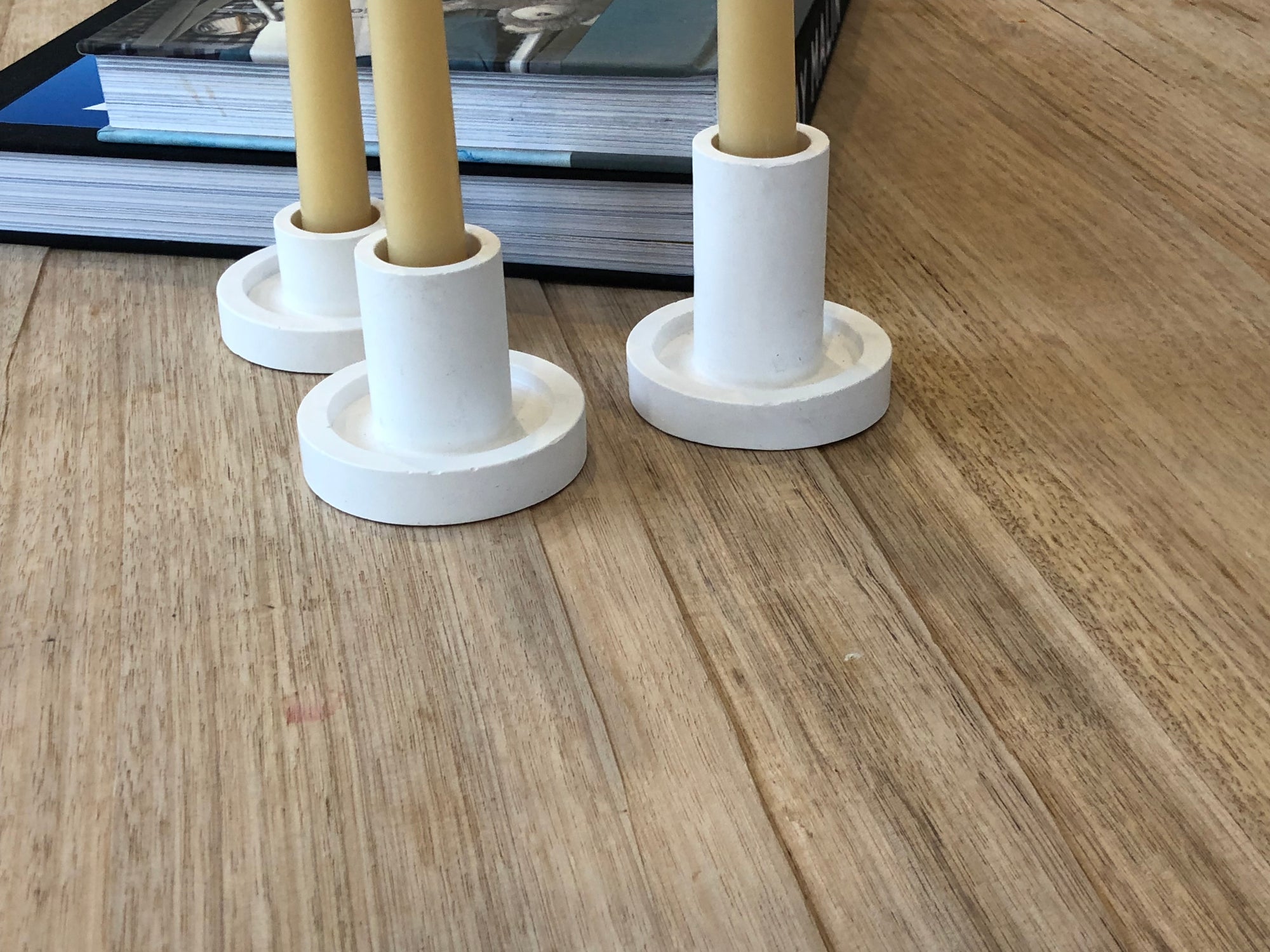 Ceiling light fixture with white cylindrical covers on a wooden  table