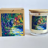 A soy candle with lavender and rosemary scents, packaged in a clear glass jar with a wooden-sealed lid, next to its colorful floral design box.