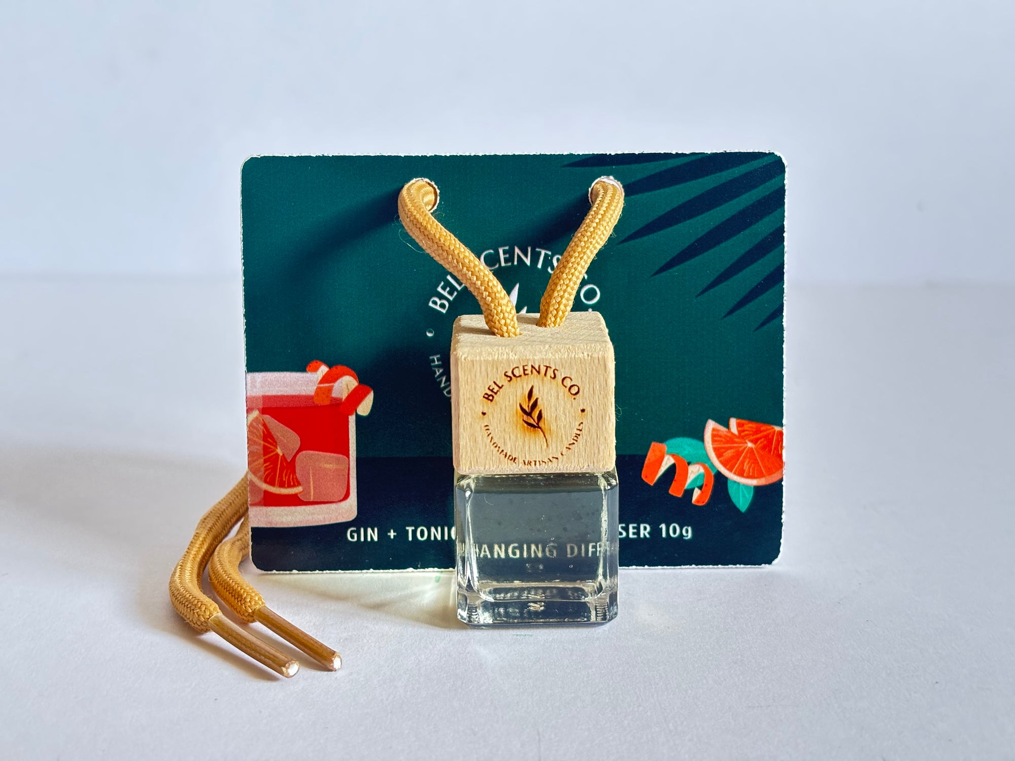 Citrus and Woody car essence. Scented hanging car diffuser bottle with wooden cap, suspended by string. Minimalist hanging diffuser for car interior. Hanging fragrance diffuser with Wood-topped diffuser adding a refreshing scent to a car interior. filled with essential oils for natural fragrance