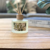 Diffuser bottle with coastal vibe design on a wooden surface coffee table