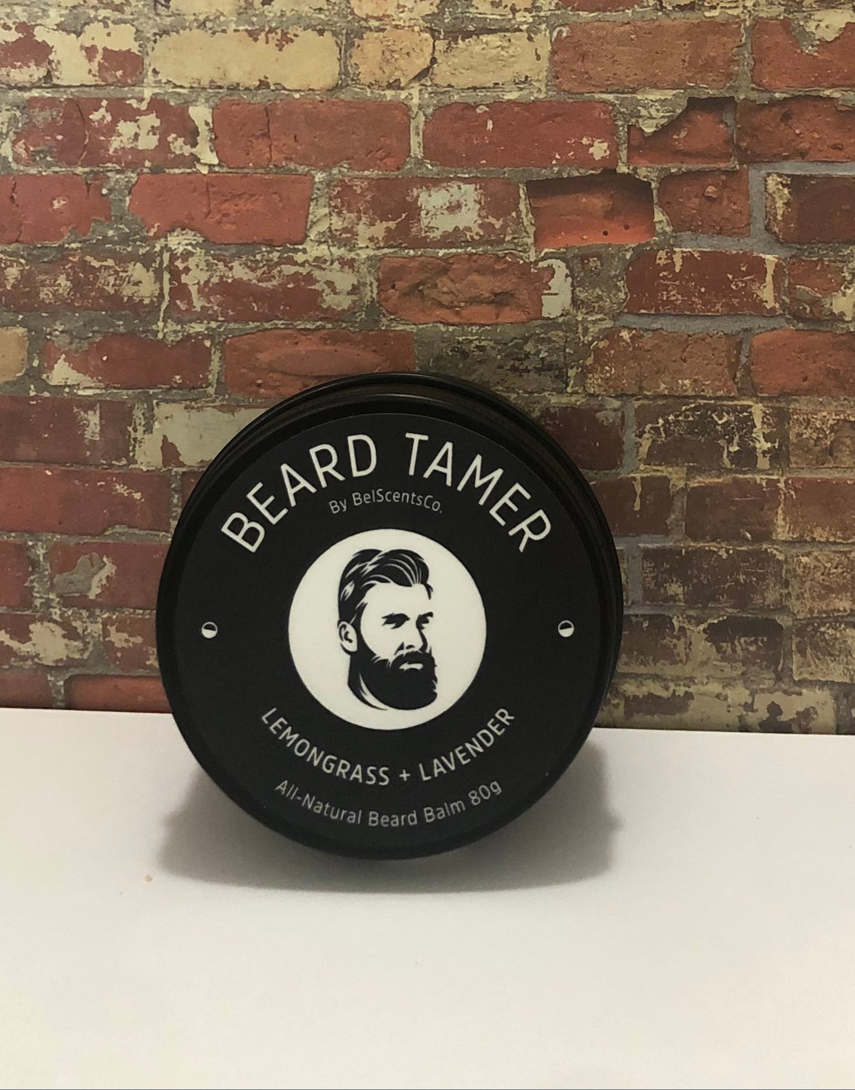 All-Natural Beard Balm for Men in Tin Container – Conditioning and Styling Balm with Essential Oils for Soft, Healthy Beard Care. Scented in Peru of Balsam Oil displayed on industrial brick wall setting