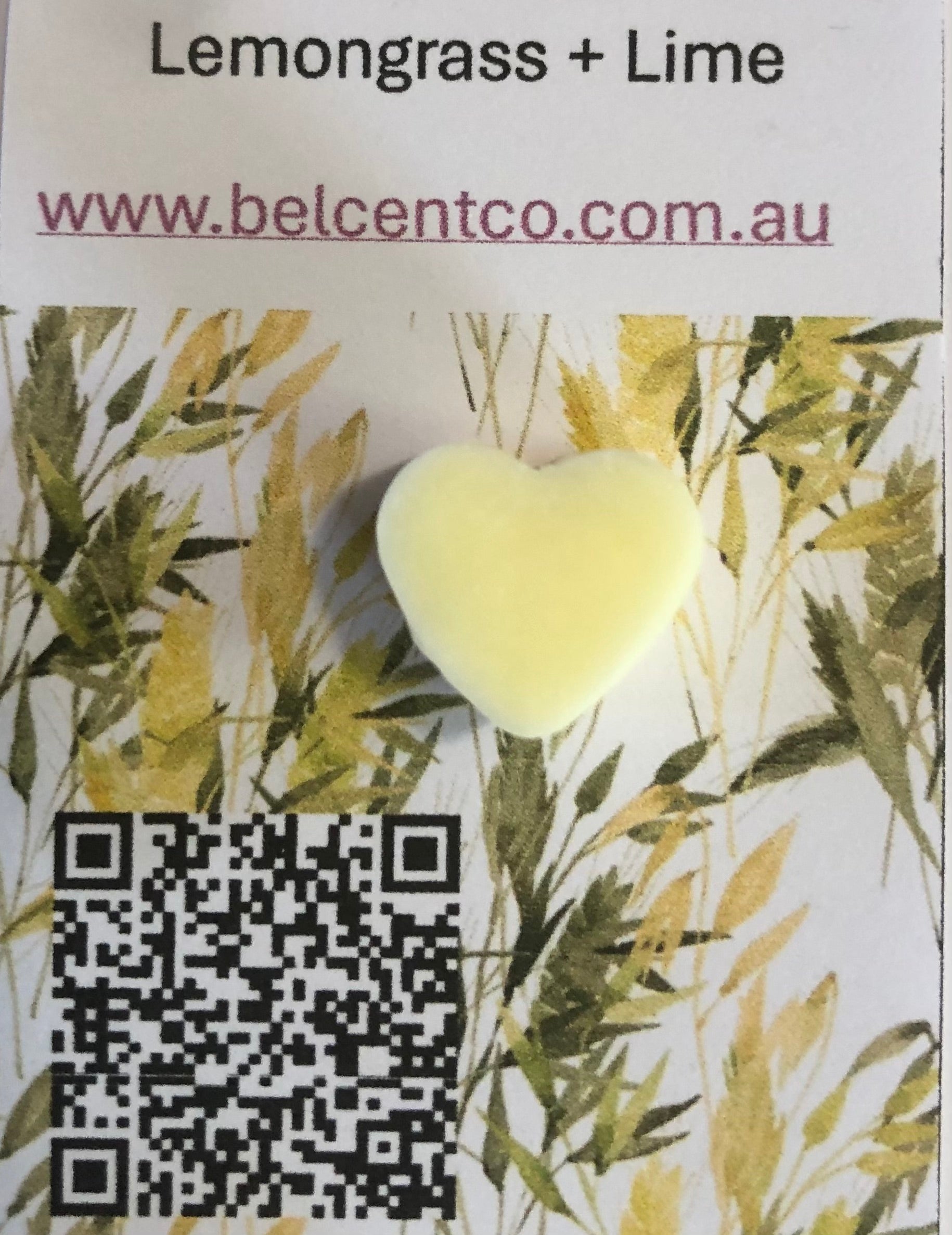 Heart-shaped product with lemongrass and lime fragrance on a branded background with QR code and website URL.