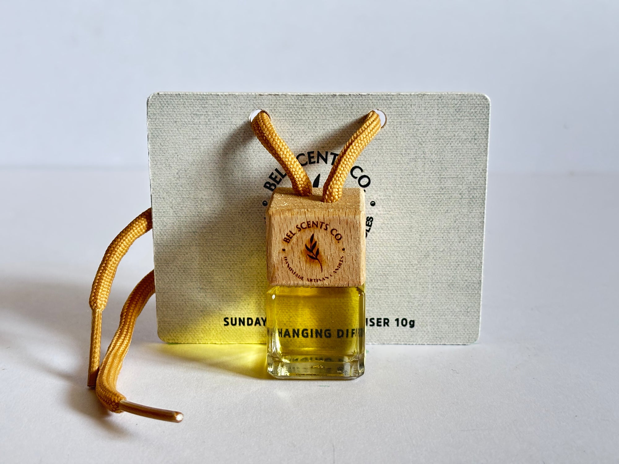 Pancake Scented hanging car diffuser bottle with wooden cap, suspended by string. Minimalist hanging diffuser for car interior. Hanging fragrance diffuser with Wood-topped diffuser adding a refreshing scent to a car interior. filled with essential oils for natural fragrance